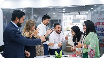 Members of the Desvert team standing together in the studio, laughing and applauding.