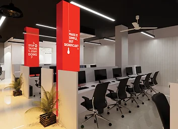 The Desvert studio floor: rows of desks and chairs beneath red pillars printed with slogans.